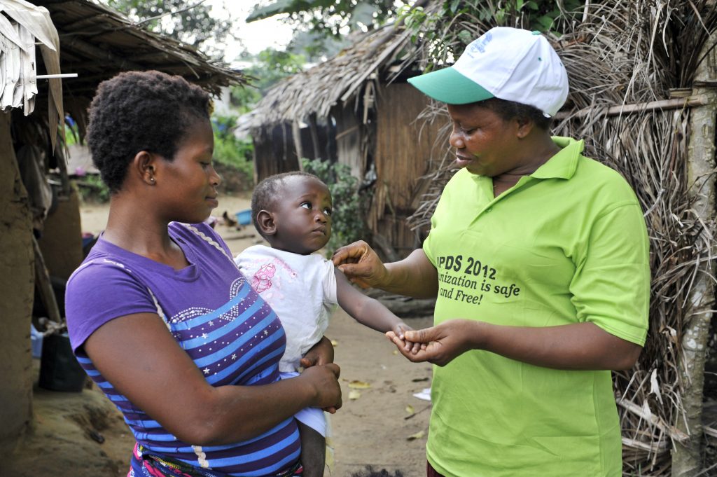 A mother holding her child that is receiving a vaccine.